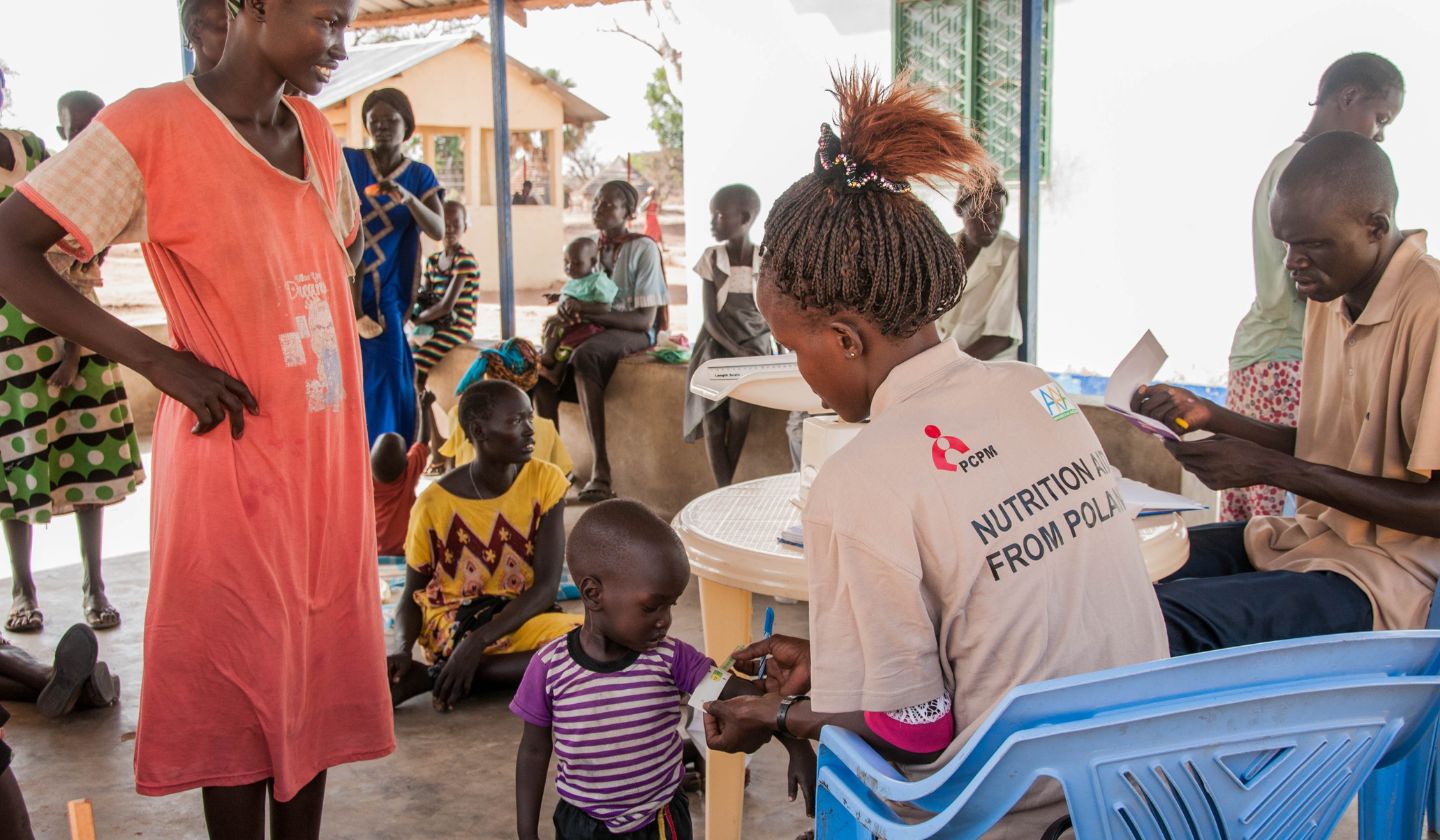 Sudan Południowy. Pracownicy Fundacji PCPM mierzy rączkę dziecku w centrum dożywiania w Gordhim.