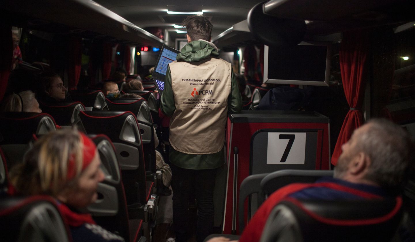 An employee of the PCPM foundation stands in a bus that evacuates people from Ukraine.
