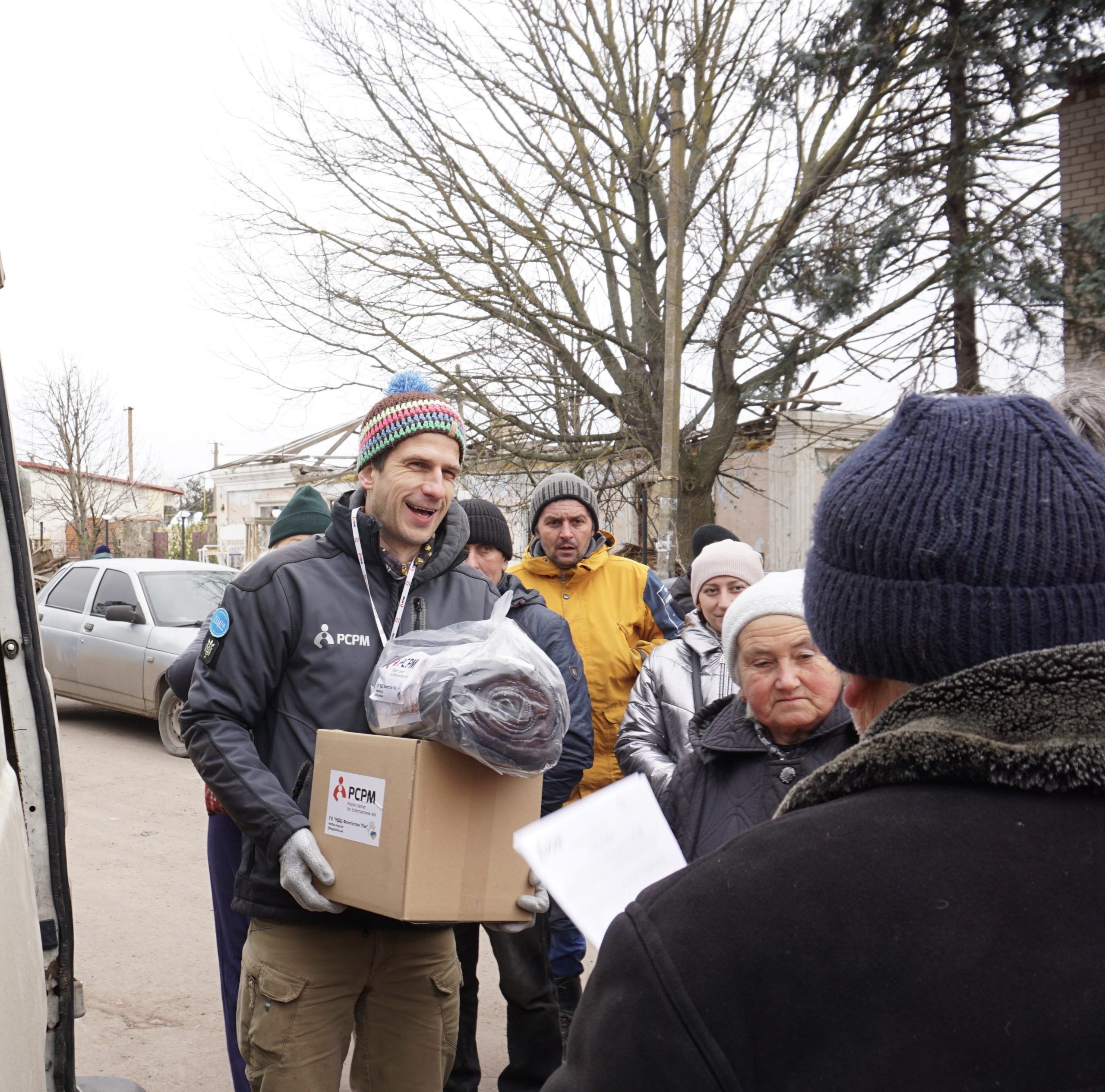 fundusz humanitarny, ubrana pomoc. Pracownik PCPM rozdający pomoc humanitarną.